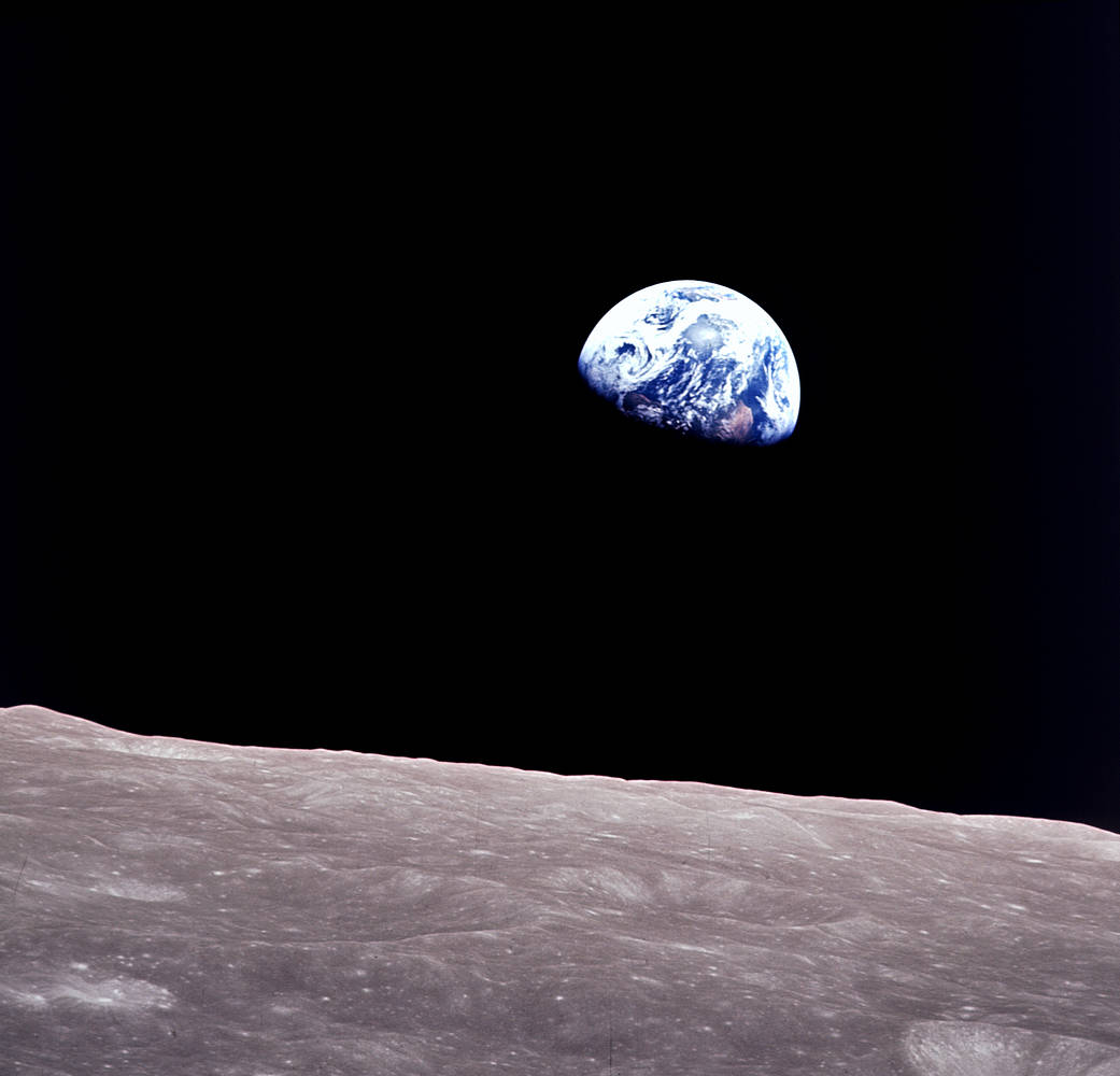 Earth rising above the Moon’s cratered horizon, photographed aboard Apollo 8.